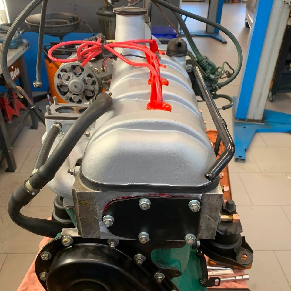 Moteur ancien avec cache-culbuteurs chromé et durites rouges