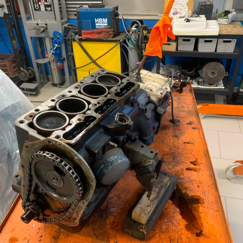 Moteur de collection posé sur un établi orange, outillage autour