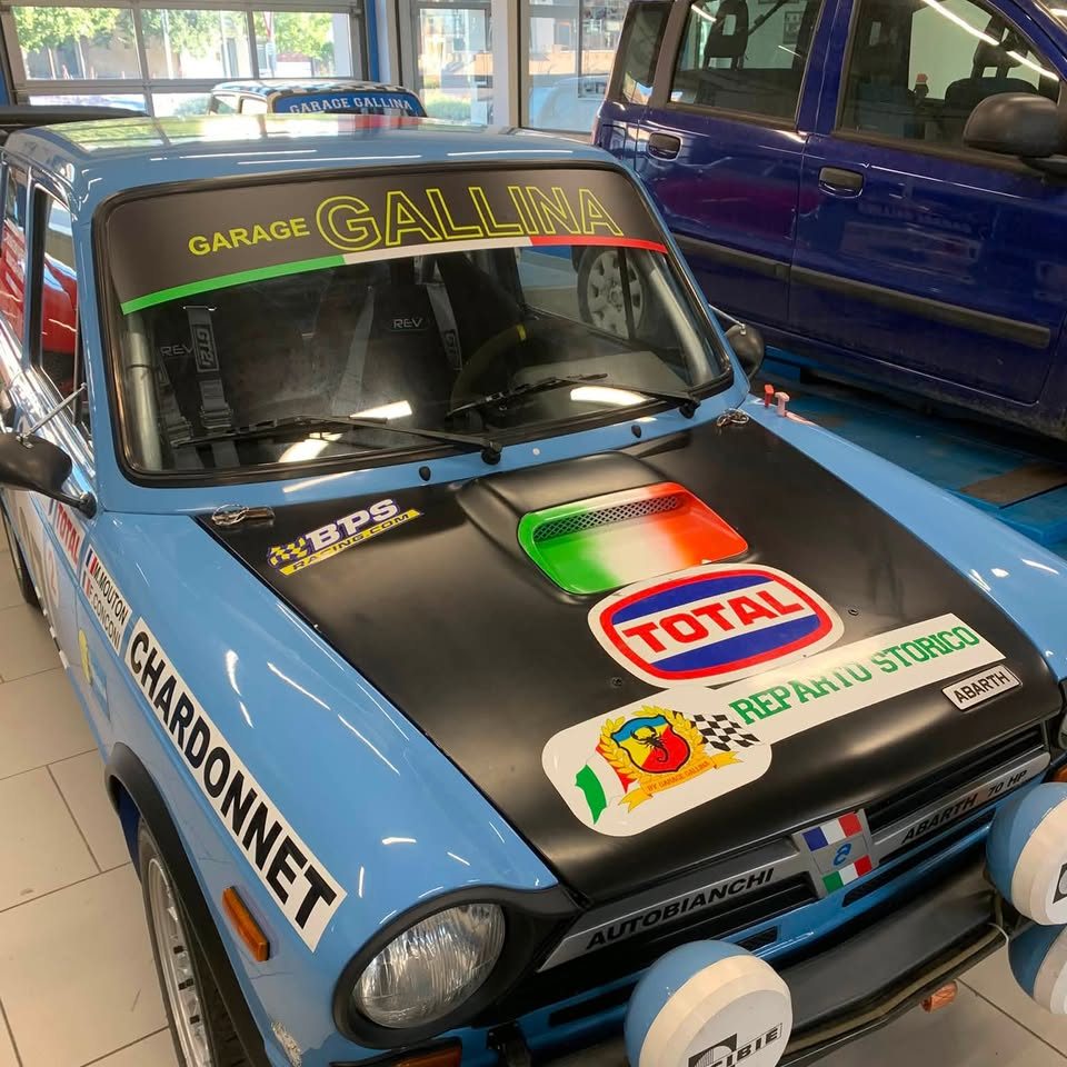 Capot noir d'une autre voiture de rallye bleue, décor Total, tricolore italien et Reparto Storico